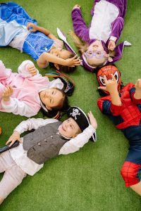 group of kids in costumes lying on the ground